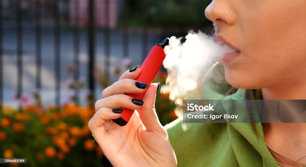 美麗的黑髮女郎抽電子煙