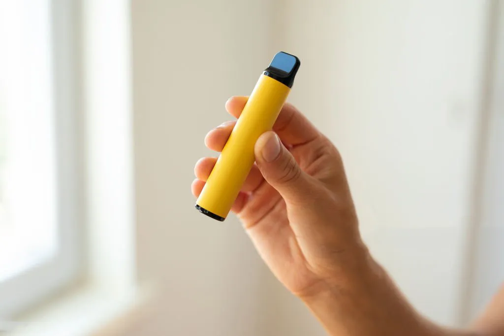 一只手拿著一個電子煙主機