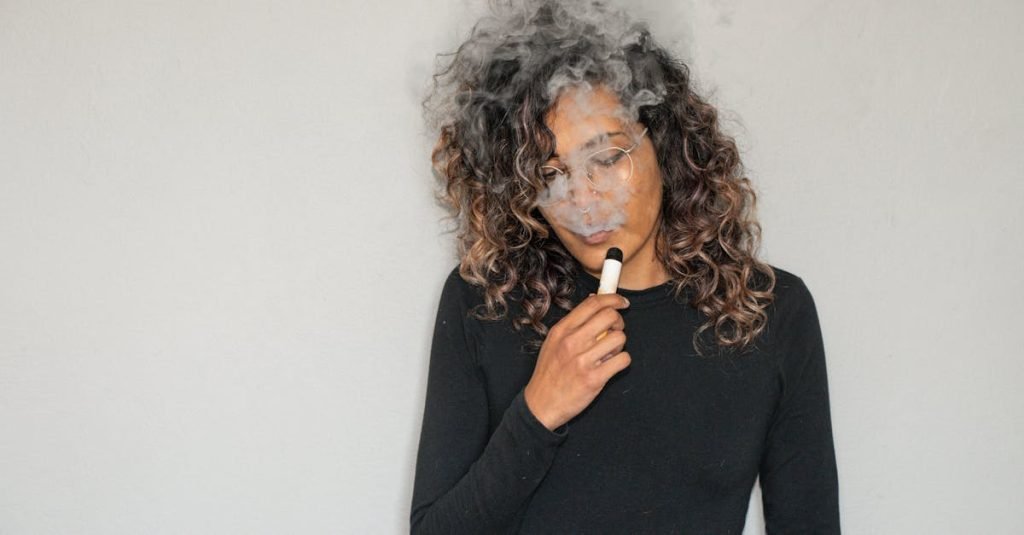 Portrait of a woman with curly hair vaping indoors, featuring smoke and a relaxed expression.